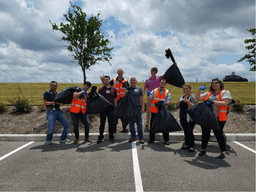 Group of people outside, geared up to pick up trash